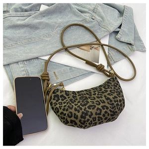 Leopard print croissant bag shown with smartphone for size comparison in a stylish setup