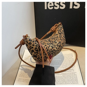 Detail of leopard print crescent bag with leather knot strap and gold zipper closure