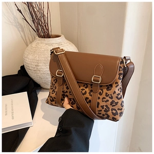 Close-up of leopard print crossbody bag with vintage metal buckle and brown leather