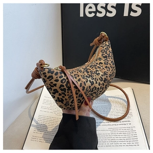 Detailed shot of leopard print crescent bag with leather tassels and knot strap detail