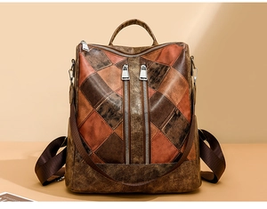 Detail of vintage patchwork leather backpack featuring geometric patterns and metal zippers