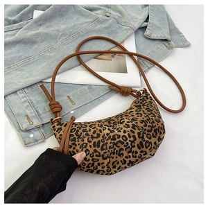 Close-up of pleated leopard print crescent bag with brown leather rope shoulder strap