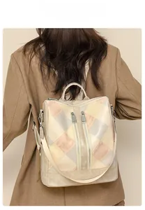 Close-up of a multi-color patchwork quilted backpack with metal zippers and beige straps