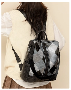 Detail view of a vintage patchwork backpack featuring geometric diamond quilting and zippers