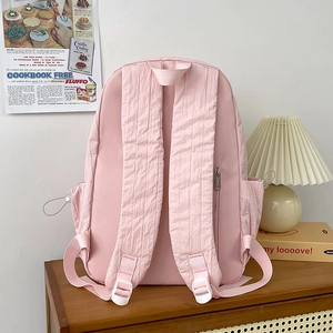 Pink nylon backpack with bubble texture, breathable padded straps and side pockets