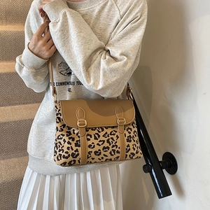 Classic leopard print crossbody bag with brown leather flap and gold buckles on a model