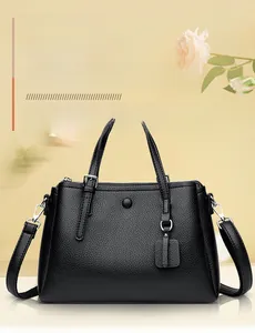 Detail of black lychee grain leather tote bag with silver hardware and rose decor