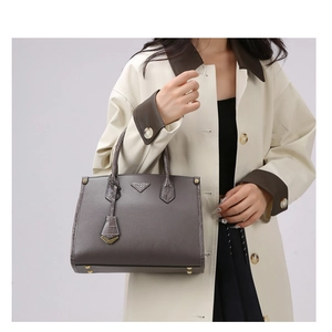 Close-up of grey leather tote bag with lychee texture and crocodile embossed details