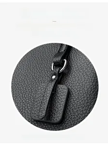 Macro detail of black lychee grain leather handbag featuring a polished silver metal ring buckle