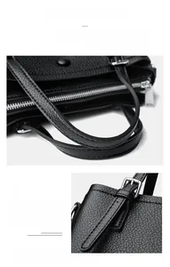 Detail of lychee textured black leather tote with silver hardware and reinforced handles