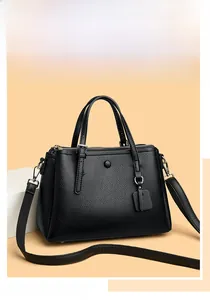 Detail of black litchi texture handbag with silver hardware and adjustable strap