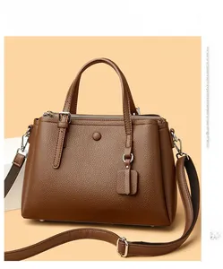 Detail view of deep brown litchi grain leather Boston bag with silver hardware and strap