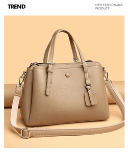 Detail of high-quality lychee pattern leather and silver hardware on khaki tote bag