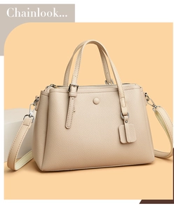 Detailed view of beige litchi leather tote bag with dual handles and elegant round buckle
