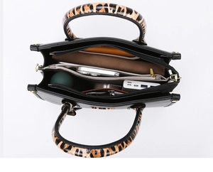 Interior view of black pebbled leather tote showing spacious compartments and leopard handles