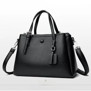 Side view of black litchi pattern leather tote bag with dual handles and shoulder strap