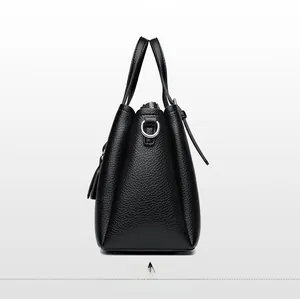 Side view of black pebble leather tote bag showing silver metal rings and zipper detail