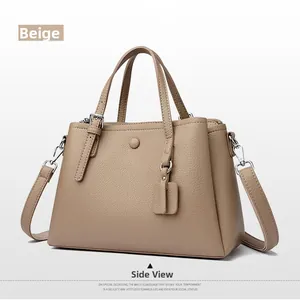 Side view of taupe lychee leather tote bag with dual handles and adjustable strap