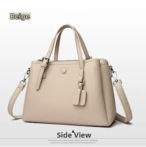 Detail view of the sand-colored lychee leather texture and the round metal buckle