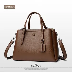 Detail view of light brown litchi pattern tote bag with adjustable strap and metal buckle