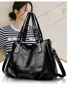 Detail of a black quilted tote bag with a silver buckle and adjustable shoulder strap