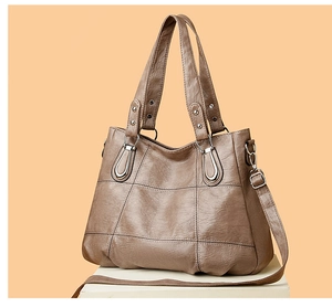 Detail of taupe leather tote bag with square stitching and adjustable shoulder strap