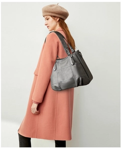 Detail of vintage grey PU leather tote bag with stylish plaid pattern and silver hardware
