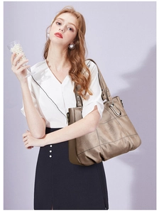 Close-up of metallic champagne tote bag with fine stitching and soft leather texture