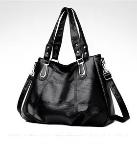 Detail of black pleated faux leather bag with diamond stitching and silver hardware