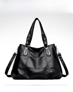 Detail of black large capacity faux leather tote bag with quilted stitching and silver hardware