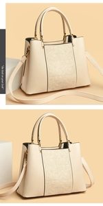 Detail of beige tote bag with floral embossing, dual handles and gold-tone hardware