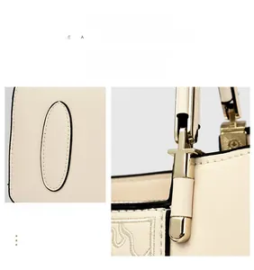 Close-up of golden metal buckle and elegant floral embroidery on beige handbag