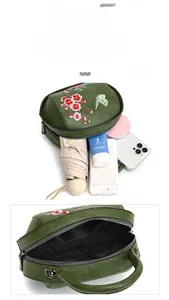 Detail showing spacious interior of dark green vintage embroidery bag with floral patterns