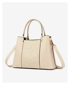 Detailed close-up of beige embroidered floral patterns on premium leather tote bag