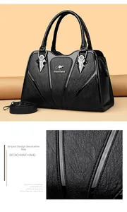Detailed view of black textured leather handbag with metallic logo and striped pattern