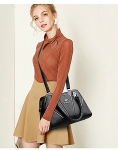 Detail of black PU leather bag with radial stitching and kangaroo metal logo accent