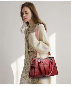 Detail of red pebbled leather bag with contrast black trim and silver hardware accents