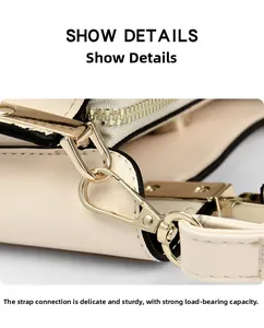 Macro detail of beige embroidered bag featuring gold metal hardware and neat stitching