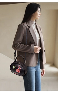 Detail of vintage brown leather bag with elegant flower and butterfly embroidery