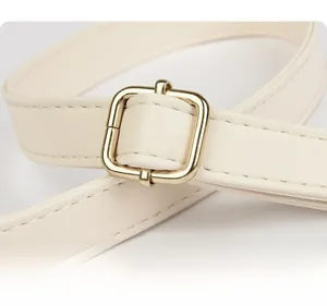 Detail of adjustable off-white PU leather strap with golden metal buckle for handbag