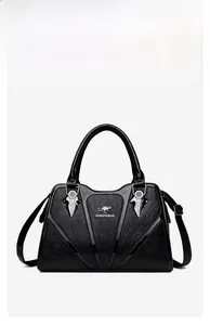Macro view of black leather handbag featuring V-shaped glossy trim and silver metal hardware