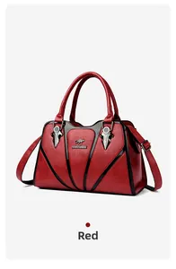 Detail of red faux leather handbag with metal kangaroo logo and black contrast piping