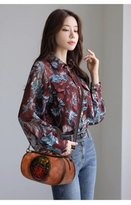 Detail of vintage cylindrical leather handbag paired with a floral printed retro blouse