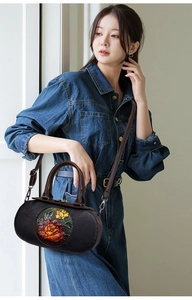 Detailed view of vintage cylindrical handbag featuring 3D embossed floral painting texture