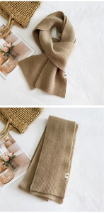 Detailed view of camel rib-knit scarf featuring soft texture and minimalist woven label