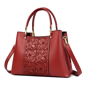 Elegant red embroidered handbag for women with floral embossing and gold hardware detail