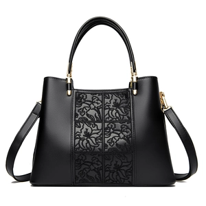 Elegant black embroidered handbag with floral pattern and golden metal hardware
