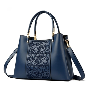 Elegant navy blue embroidered handbag with floral relief and golden metal hardware