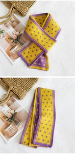 Dettaglio della sciarpa in maglia gialla e viola con motivi floreali e texture morbida