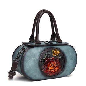 Retro teal cylinder handbag with embossed peony floral design and brown leather straps
